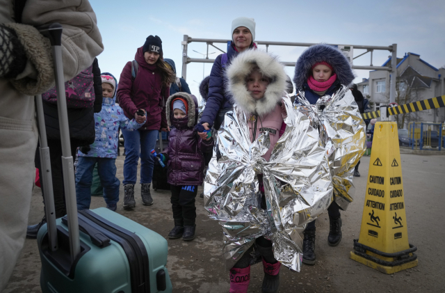 지난 10일(현지시간) 몰도바의 국경 도시 팔랑카에서 피란 행렬을 이룬 우크라이나 어린이들이 추위를 쫓기 위해 보온용 은박지를 온몸에 두르고 있다. AP연합뉴스