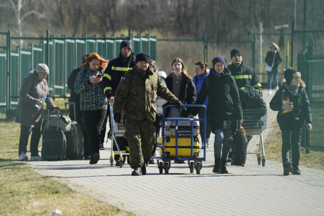 폴란드 남동부 국경도시 메디카에서 27일(현지 시간) 우크라이나 난민들이 걸어서 국경을 넘고 있다. 연합뉴스