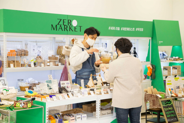 홈플러스 서울 남현동 매장에 자리한 ‘제로마켓’을 찾은 고객이 직원으로부터 상품에 대한 설명을 듣고 있다./홈플러스