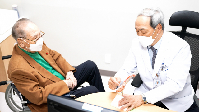 노성훈 교수(오른쪽)가 잔위암 수술을 받은 박상길씨에게 수술 후 관리법에 대해 설명하고 있다. 사진 제공=강남세브란스병원