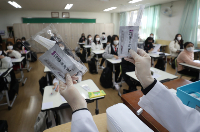 울산의 한 중학교 보건교사가 학생들에게 신속항원검사 도구 사용법을 설명하고 있다. 울산=연합뉴스