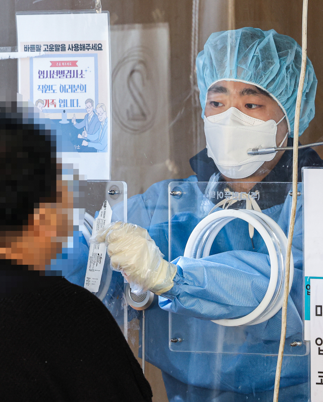 29일 오전 서울 중구 서울역 선별진료소에서 관계자가 PCR 검사를 시행하고 있다. /연합뉴스