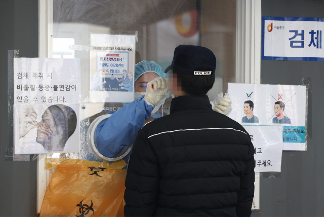 서울역광장에 설치된 코로나19 임시선별검사소에서 시민이 30일 검사를 받고 있다. 중앙방역대책본부는 이날 0시 기준으로 신규 확진자가 42만4641명 늘었다고 밝혔다. 연합뉴스