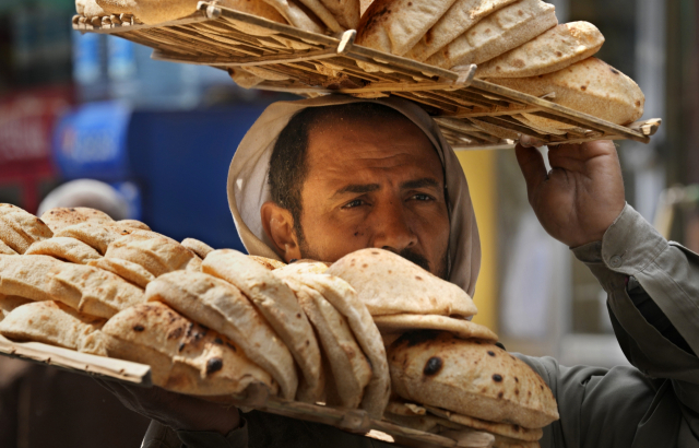 한 상인이 22일(현지 시간) 이집트 카이로에서 빵을 운반하고 있다. AP연합뉴스