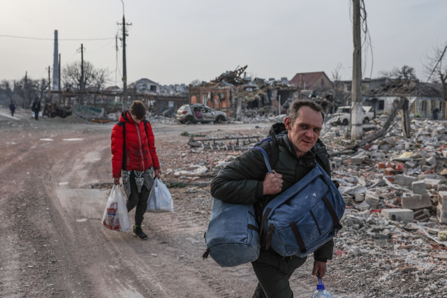 우크라이나 남부 항구도시 마리우폴에서 지난달 31일(현지시간) 주민들이 폐허로 변한 삶터를 뒤로 하고 피란길을 나서고 있다. 러시아 정부는 이날부터 마리우폴에서 자국 자포리자로 이어지는 주민 대피용 '인도주의 통로'를 개설한다고 밝혔다. 마리우폴은 지난달 초부터 러시아군의 포위 공격으로 주택 대부분이 파괴되고 식량, 수돗물, 전기 공급이 끊겼다. 연합뉴스