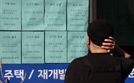 서울의 한 부동산 앞에서 매매 목록을 살피는 모습. /연합뉴스