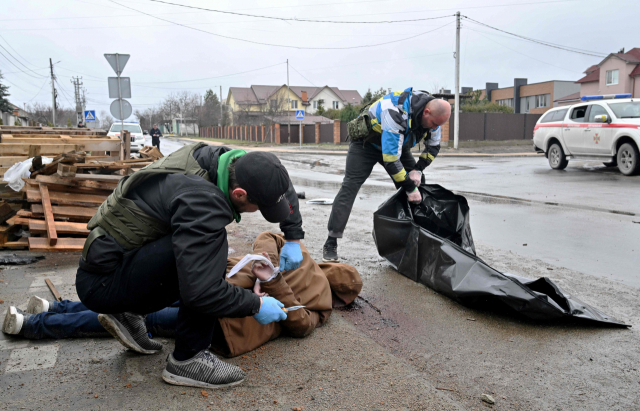 우크라이나 부차에서 3일(현지 시간) 공공 근로자들이 길거리에 누워 있던 시신들을 수습하고 있다. AFP연합뉴스