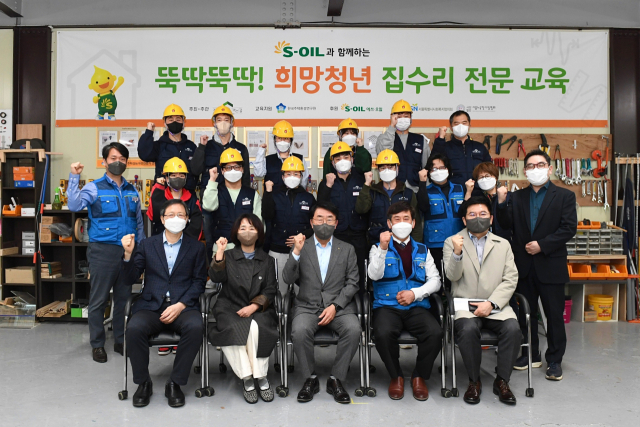 5일 경기도 성남시 한국주택환경연구원에서 열린 집수리 전문교육 후원금 전달식에서 김평길(앞줄 왼쪽 세번째) 에쓰오일 전무가 관계자들과 파이팅을 외치고 있다. 사진제공=에쓰오일