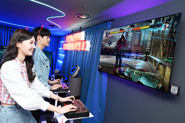 LG전자 모델들이 부산 광안리에서 마련한 ‘금성오락실’에서 올레드 TV로 게임을 즐기고 있다.
