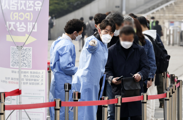 6일 서울역 임시 선별검사소에서 관계자들이 코로나19 검사 대기 중인 시민들에게 관련 안내를 하고 있다. 연합뉴스