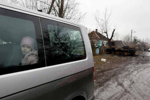 지난 3일(현지시간) 우크라이나 북부 체르니히우 내 노바 바산 마을에서 창밖을 바라보는 한 소녀의 모습. 로이터 연합뉴스