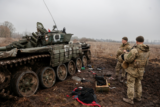 1일(현지시간) 우크라이나 체르니히프 지역 노바바산 마을에서 러시아의 우크라이나 공격이 계속되는 가운데 우크라이나 군 장병들이 막힌 러시아 탱크를 점검하고 있다. 로이터 연합뉴스