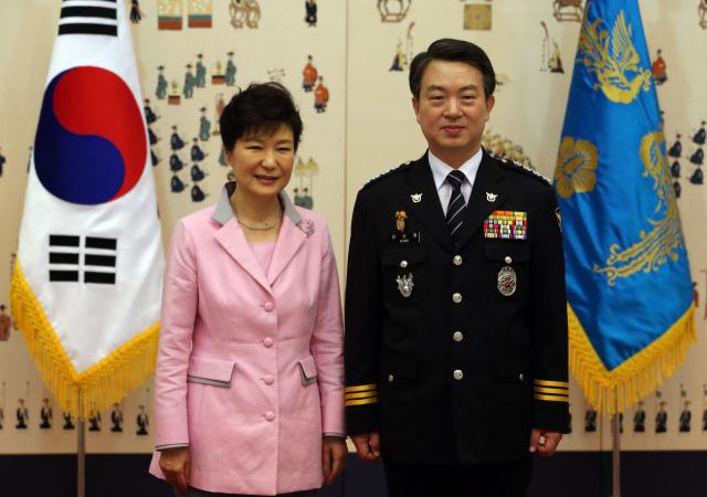 2014년 8월 27일 박근혜(왼쪽) 대통령이 청와대에서 강신명 경찰청장에게 임명장을 수여한 뒤 기념촬영하고 있다. 연합뉴스