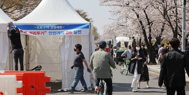 여의도 벚꽃길(여의서로) 개방을 하루 앞둔 지난 8일 오후 교통 통제된 서울 여의서로 벚꽃길에서 관계자들이 거리두기 관련 안내문을 설치하고 있다. 연합뉴스