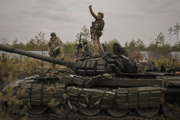 지난달 31일(현지시간) 우크라이나군 병사가 수도 키이우 외곽에서 파괴된 러시아군 탱크 위에 올라 서서 사진을 찍고 있다. AP 연합뉴스