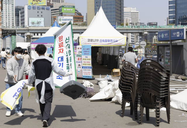 지난 10일 서울 중구 서울역 임시 선별검사소의 신속항원검사 완료자 대기장소가 철거되고 있다. 연합뉴스