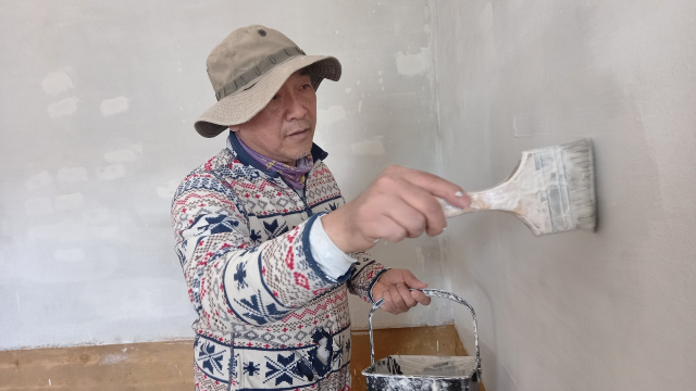 함승호 적정기술공방 대표가 경북 문경시 평지리 신축 주택 공사 현장에서 벽에 페인트를 칠하고 있다.