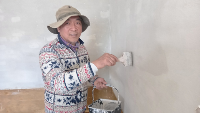 함승호 적정기술공방 대표가 경북 문경시 평지리 신축 주택 공사 현장에서 벽에 페인트를 칠하고 있다.