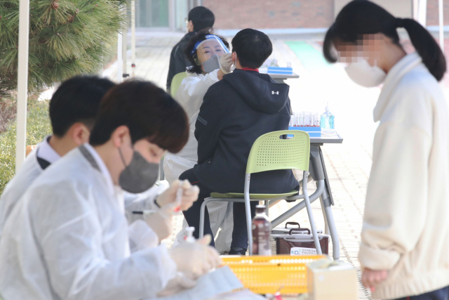 서울 관악구 인헌중학교 학생들이 지난달 16일 학교에 설치된 이동형 유전자증폭(PCR) 검사소에서 검사를 받고 있다. 연합뉴스