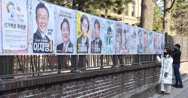 지난 2월 18일 서울 종로구 예술가의 집 울타리에 종로구선관위 관계자들이 선거 벽보를 첩부하고 있다. /오승현 기자
