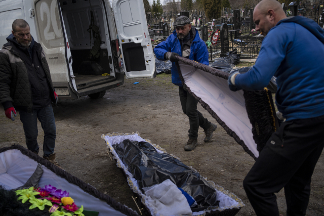 11일(현지시간) 우크라이나 키이우 외곽의 부카에서 묘지 직원들이 러시아와의 전쟁 중 숨을 거둔 이들을 수습하기 위해 관을 준비하고 있다. AP 연합뉴스
