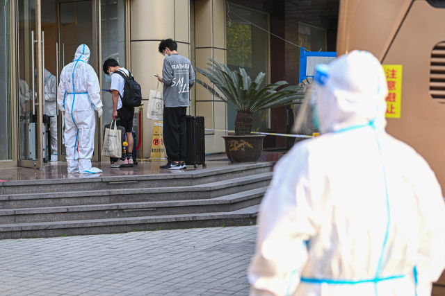 11일(현지시간) 신종 코로나바이러스 감염증(코로나19) 격리 대상자들이 중국 항저우의 한 호텔에 도착해 이동하고 있다. 신화 연합뉴스