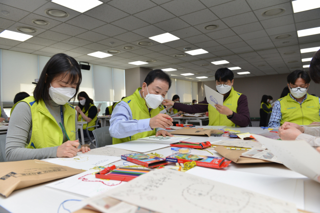 최문섭(왼쪽 두 번째) NH농협손해보험 대표이사와 직원 40여명이 지난 8일 서울 양천구에 위치한 사단법인 ‘사람과사람’을 방문해 어르신들의 치매예방을 위한 색칠공부책을 제작하고 있다. 사진 제공=NH농협손보