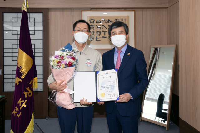 고성욱(왼쪽) 휴비스 전주공장장이 전주상공회의소에서 진행된 제49회 상공의 날 수상식에서 윤방섭 전주상공회의소 회장과 함께 기념사진을 촬영하고 있다. 사진제공=휴비스