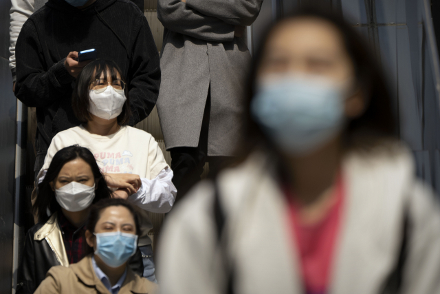 13일 코로나 19가 재창궐한 중국 상하이에서 마스크를 착용한 행인들이 거리를 지나고 있다. AP연합뉴스