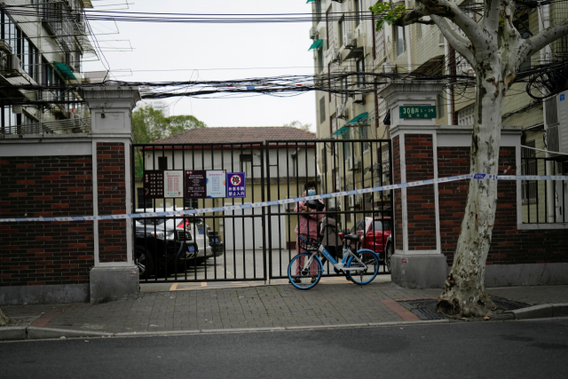 13일 중국 상하이에서 코로나19로 인해 봉쇄령이 내려진 가운데 한 주민이 봉쇄된 주택가 출입구에 서있다. 로이터연합뉴스