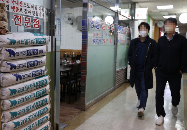 서울 지역의 칼국수 평균 가격이 8000원을 처음 돌파했다. 직장인들이 14일 오후 서울 시내 칼국수 식당을 지나가고 있다. 연합뉴스