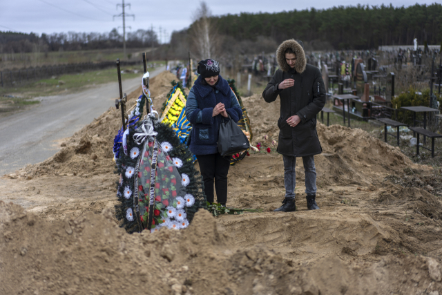나탈리야 베르보바(왼쪽)가 13일(현지 시간) 우크라이나 부차 공동묘지에 묻힌 남편의 묘지 앞에 서 있다. 오른쪽은 그의 아들. AP연합뉴스
