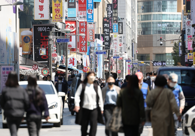 정부가 사회적 거리두기 도입 2년 1개월 만에 전면 해제를 결정한 15일 서울 시내의 한 식당가에서 마스크를 쓴 시민들이 이동하고 있다. 연합뉴스