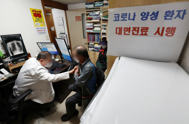 이달 4일 서울 은평구의 한 의원에서 의사가 코로나19 확진자를 대면 진료하고 있다. 연합뉴스