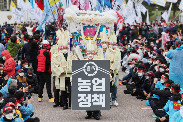 전국농민회총연맹(전농) 관계자들이 13일 오후 서울 여의도공원 문화의마당에서 포괄적·점진적 환태평양 경제동반자 협정(CPTPP) 가입 저지 전국농어민 집회에서 깃발 입장과 함께 상복 퍼포먼스를 하고 있다. 연합뉴스