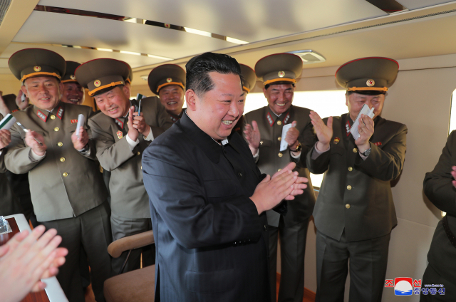 북한 김정은 국무위원장이 자칭 '신형 전술유도무기' 시험발사를 참관한 뒤 박수를 치고 있는 모습. /연합뉴스·조선중앙통신