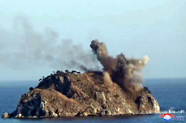 일명 ‘알섬’으로 추정되는 해상의 한 섬에서 미사일 타격에 따른 폭발 충격으로 연기가 일어나는 모습/조선중앙통신·연합뉴스