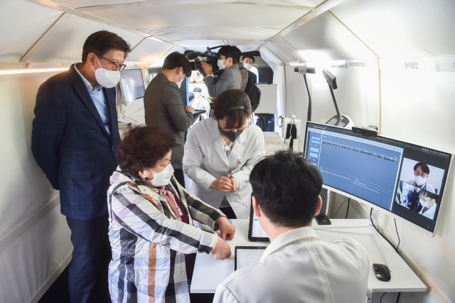 박형준(왼쪽) 부산시장이 첨단 정보통신기술(ICT) 기반의 찾아가는 의료 서비스인 ‘의료버스’에서 의료진의 원격 협진을 참관하고 있다. 사진 제공=부산시