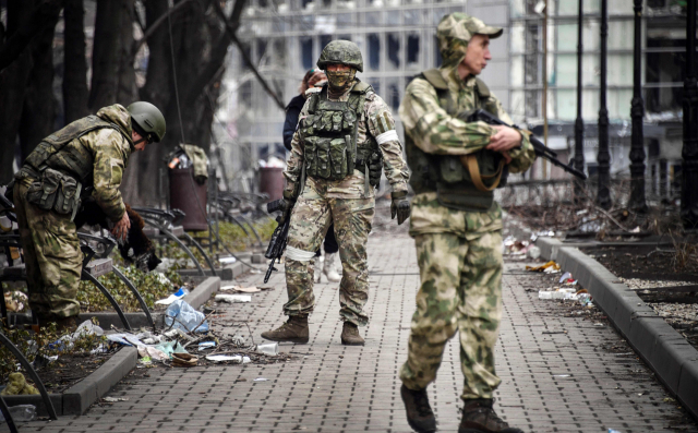 지난 12일(현지시간) 우크라이나 마리우폴에서 러시아 군인들이 엉망이 된 거리를 거닐고 있다. AFP 연합뉴스