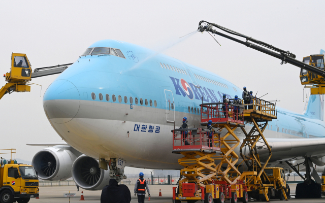 사회적 거리두기 전면 해제 첫날인 18일 오전 영종도 인천국제공항 대한항공 정비 격납고에서 관계자들이 보잉 747-8i 항공기 동체를 세척하고 있다. 이날 묵은 때를 벗고 새 단장을 한 항공기는 장거리 노선에 투입되는 보잉747-8i로 동체, 날개뿐 아니라 엔진 내부 구석구석까지 먼지와 이물질을 말끔히 제거했다. 동체를 포함한 항공기 외부 세척에는 26m까지 상승하는 차량 탑재형 고소 작업대 1대, 중대형 리프트카 3대, 물탱크 차량 3대가 투입됐다./영종도=권욱 기자 2022.04.18