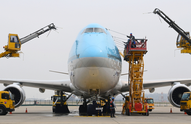 사회적 거리두기 전면 해제 첫날인 18일 오전 영종도 인천국제공항 대한항공 정비 격납고에서 관계자들이 보잉 747-8i 항공기 동체를 세척하고 있다. 이날 묵은 때를 벗고 새 단장을 한 항공기는 장거리 노선에 투입되는 보잉747-8i로 동체, 날개뿐 아니라 엔진 내부 구석구석까지 먼지와 이물질을 말끔히 제거했다. 동체를 포함한 항공기 외부 세척에는 26m까지 상승하는 차량 탑재형 고소 작업대 1대, 중대형 리프트카 3대, 물탱크 차량 3대가 투입됐다./영종도=권욱 기자 2022.04.18