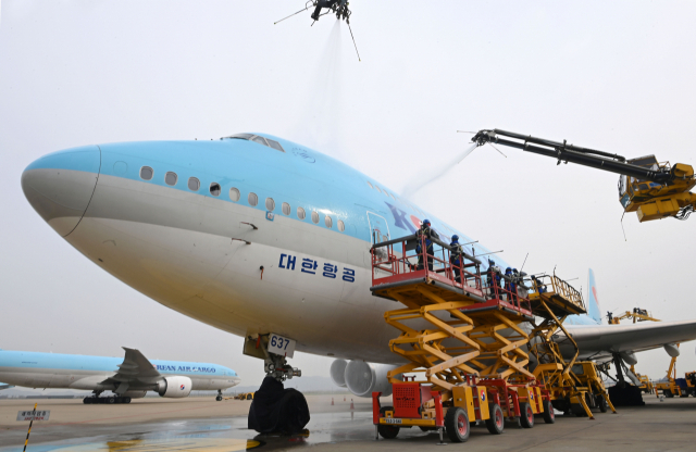 사회적 거리두기 전면 해제 첫날인 18일 오전 영종도 인천국제공항 대한항공 정비 격납고에서 관계자들이 보잉 747-8i 항공기 동체를 세척하고 있다. 이날 묵은 때를 벗고 새 단장을 한 항공기는 장거리 노선에 투입되는 보잉747-8i로 동체, 날개뿐 아니라 엔진 내부 구석구석까지 먼지와 이물질을 말끔히 제거했다. 동체를 포함한 항공기 외부 세척에는 26m까지 상승하는 차량 탑재형 고소 작업대 1대, 중대형 리프트카 3대, 물탱크 차량 3대가 투입됐다./영종도=권욱 기자 2022.04.18