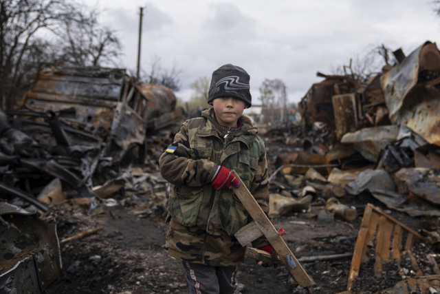 17일(현지 시간) 우크라이나 북부 도시 체르니히우의 러시아군 차량 잔해 주변에서 7세 소년이 목총을 들고 서 있다. 러시아가 우크라이나 동부 돈바스 지역에 총공세를 펼 것이라는 전망이 나오는 가운데 러시아군은 수도 키이우와 르비우·하르키우·도네츠크 등 주요 도시에 대한 공습을 이어가고 있다. AP연합뉴스