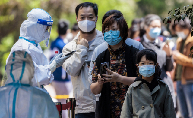 16일 중국 상하이의 한 폐쇄된 주택가에서 코로나19 검사를 받기 위해 시민들이 줄을 서 있다. EPA 연합뉴스