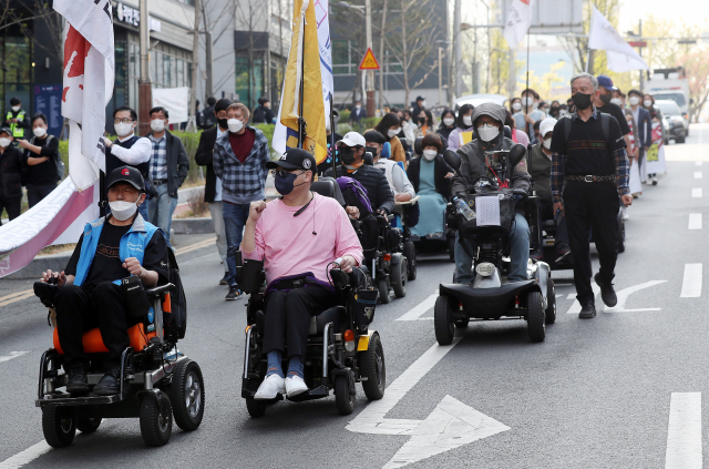 장애인의 날을 이틀 앞둔 18일 오후 인천시 남동구 인천시청 인근 도로에서 4.20 장애인차별철폐 인천공동투쟁단 회원들이 장애인 차별 철폐를 촉구하며 행진하고 있다./연합뉴스