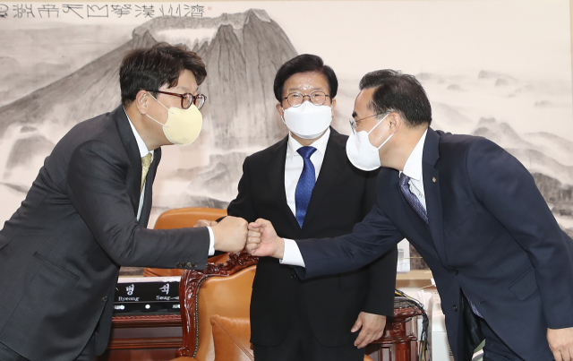 박홍근(오른쪽) 더불어민주당 원내대표와 권성동(왼쪽) 국민의힘 원내대표가 19일 국회 의장실에서 박병석 국회의장이 보는 앞에서 주먹 인사를 하고 있다. 성형주 기자