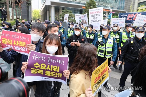 20일 오후 서울 종로구 옛 일본대사관터 인근에서 수요시위 정상화를 촉구하는 시민과 이에 반대하는 시민들이 각기 다른 주장이 담긴 피켓을 들고 있다. 연합뉴스