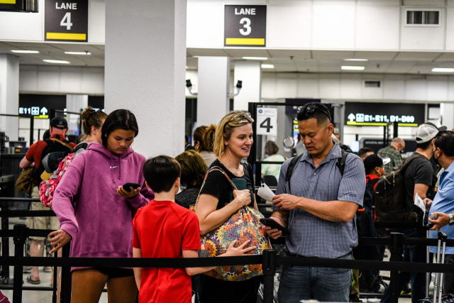 대중교통 내 마스크 착용 의무화 조치가 폐지된 19일(현지 시간) 미국 플로리다주 마이애미 국제공항에서 마스크를 쓰지 않은 여행객들이 보안 검색대 통과를 기다리고 있다. AFP연합뉴스