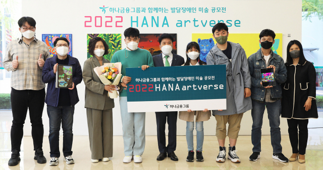 함영주(가운데) 하나금융그룹 회장이 서울 을지로 하나은행 본점에서 열린 ‘하나 아트버스(Hana Artverse)’ 시상식이 끝난 뒤 기념 촬영을 하고 있다. 하나 아트버스는 하나금융그룹이 디지털을 활용해 발달 장애인의 예술을 가상 영역 범위까지 확대한 미술 공모전이다. 사진 제공=하나금융그룹