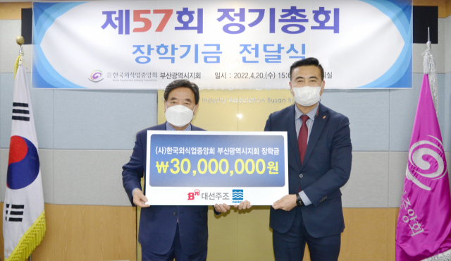 20일 ‘제57회 한국외식업중앙회 부산시지회 정기총회’에서 김상준(오른쪽) 대선주조 지점장이 강인중 한국외식업중앙회 부산광역시지회에게 소속회원 자녀들을 위한 장학금 3000만 원을 전달했다./사진제공=대선주조